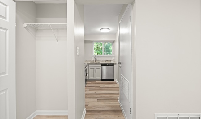 closet looking down a hall with wood flooring
